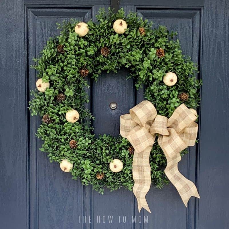 blue front door with neutral boxwood wreath