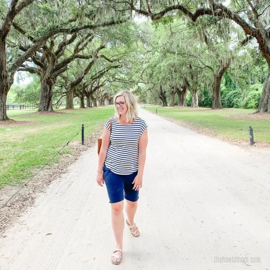 woman wearing knee length shorts under canopy of southern oak trees.
