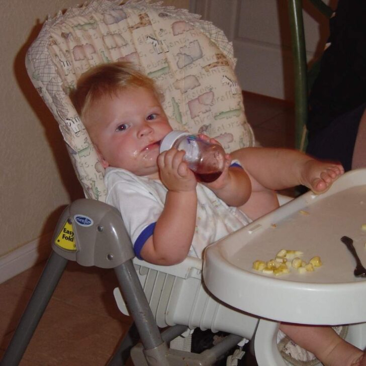 Toddler eating in high chair.